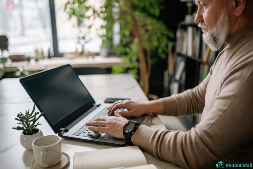 Man in Gray Long Sleeve Shirt Using Black Laptop Computer