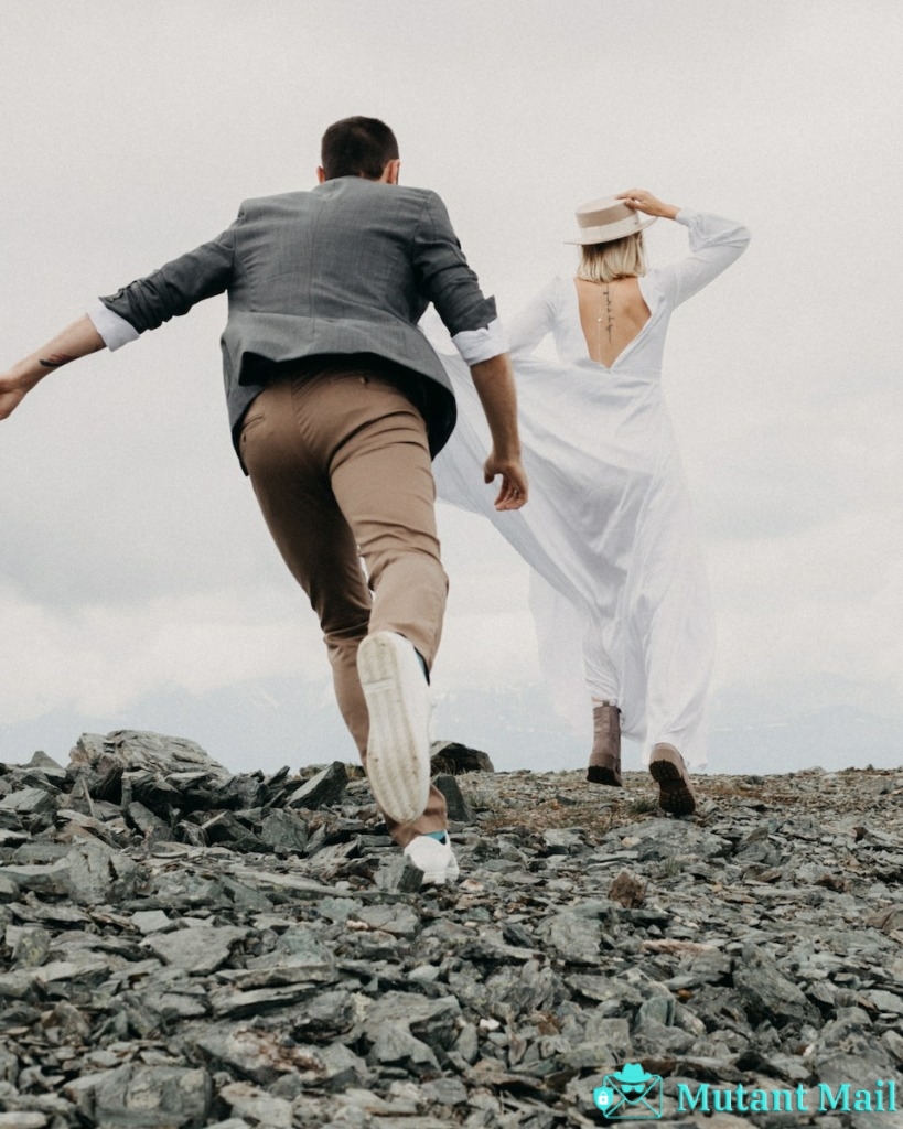 Anonymous groom catching up bride on rocky land